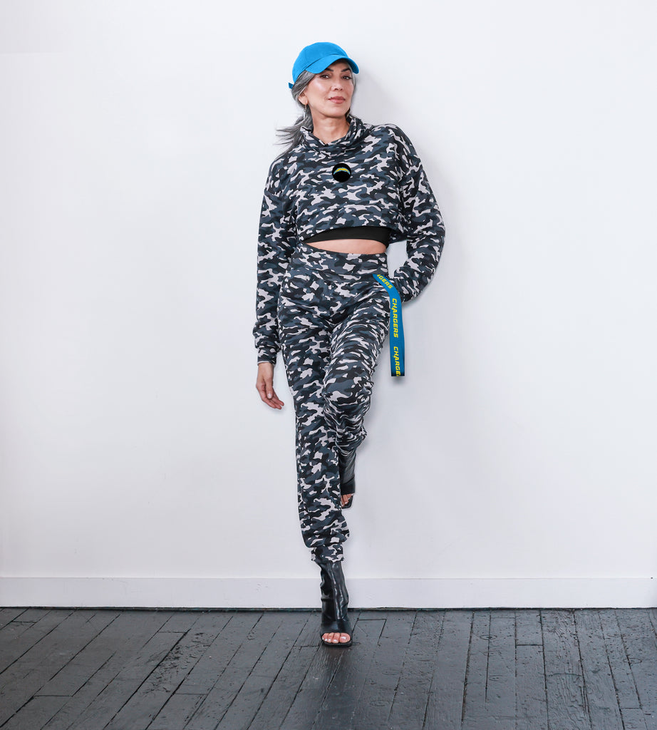 This jogger has a camo print and a comfortable yoga-style waistband that adjusts easily. It features a ribbon with the team name script attached to the left hip for a touch of team spirit.