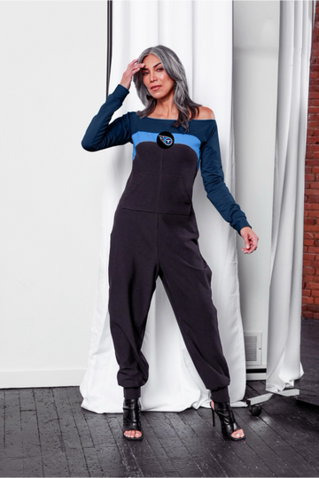 Off shoulder jumpsuit with dark blue sleeves, blue stripe, black body, and Titans logo on the center of the chest with front patch pockets.