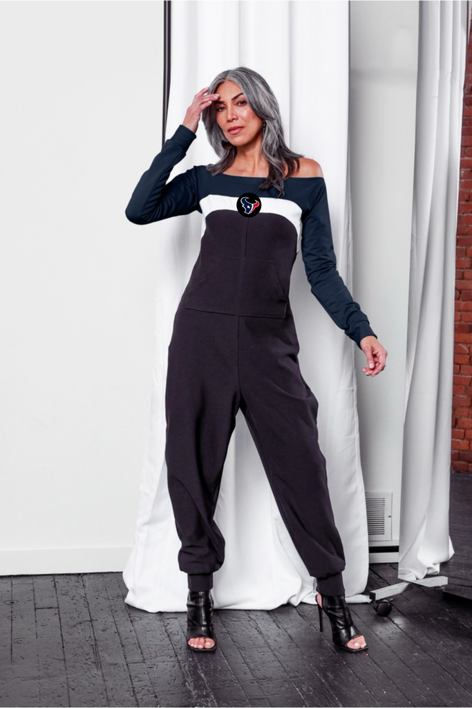 Off shoulder jumpsuit with dark blue sleeves, white stripe, black body, and Texans logo on the center of the chest with front patch pockets. 