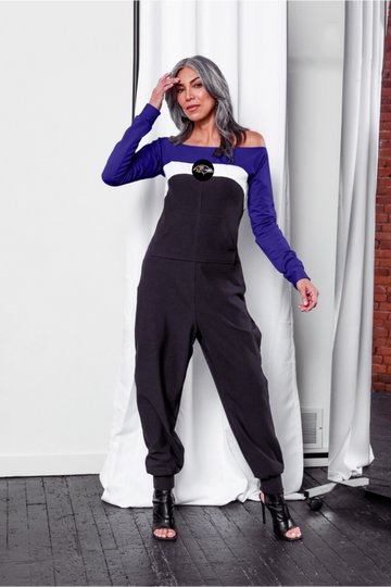 Off shoulder jumpsuit with purple sleeves, white stripe, and black body with Ravens logo on the center of the chest and front patch pockets. 