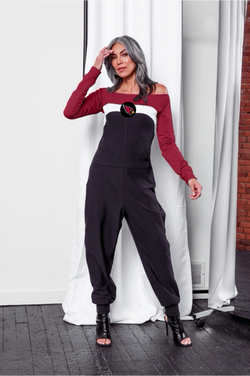 Off shoulder jumpsuit with red sleeves, white strip, and black body; front patch pocket, and cardinal logo on the center of chest.