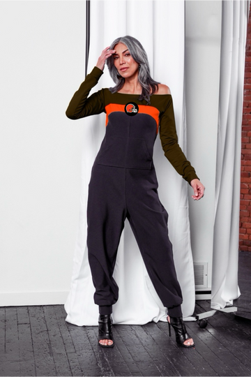 Off shoulder jumpsuit with brown sleeves, orange stripe, black body, and Browns logo on the center of the chest with front patch pockets. 